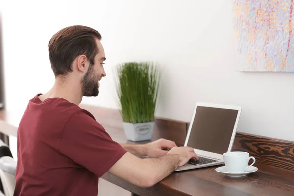 Αρσενικό ελεύθερος επαγγελματίας εργάζεται με φορητό υπολογιστή στο γραφείο στο σπίτι — Φωτογραφία Αρχείου