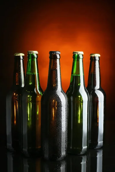 Φρέσκια μπύρα σε γυάλινες φιάλες σε σκούρο φόντο — Φωτογραφία Αρχείου