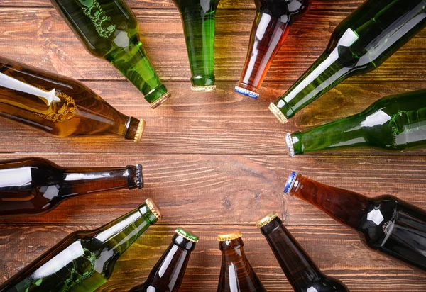 Свіже пиво в скляних пляшках на дерев'яному фоні — стокове фото