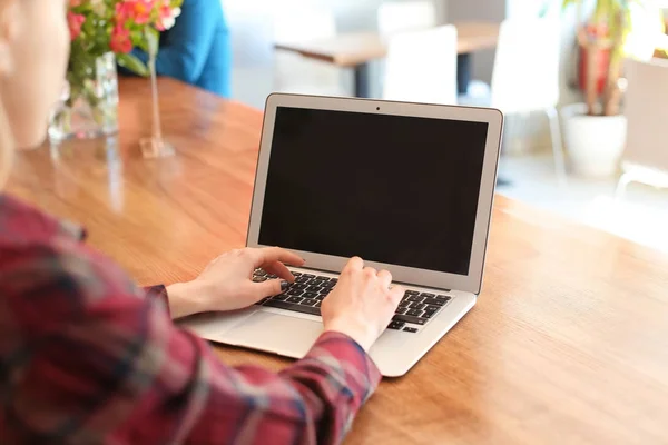 Junge Frau benutzt Laptop am Tisch in Café — Stockfoto