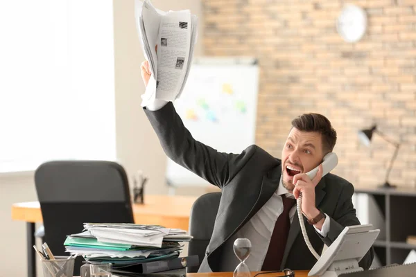Emotionaler Geschäftsmann mit Telefon und Sanduhr am Tisch im Büro. Zeitmanagement-Konzept — Stockfoto