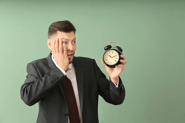 色の背景上の目覚まし時計で実業家。時間管理の概念 — ストック写真
