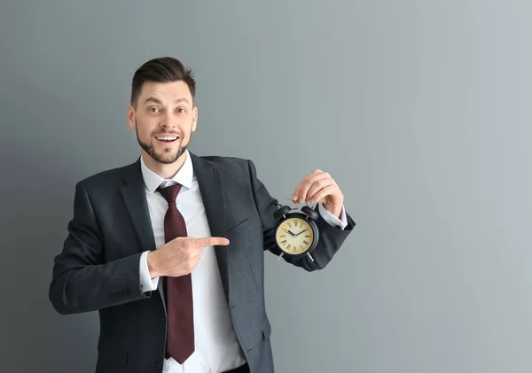 회색 배경에 알람 시계와 사업가입니다. 시간 관리 개념 — 스톡 사진