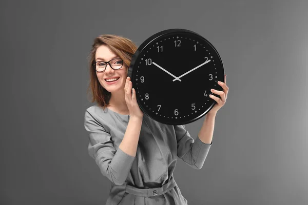 Mogen kvinna med klocka på grå bakgrund. Time management koncept — Stockfoto