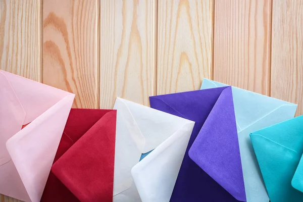 Ahşap arka plan, üstten görünüm renkli zarflara. Posta hizmeti — Stok fotoğraf