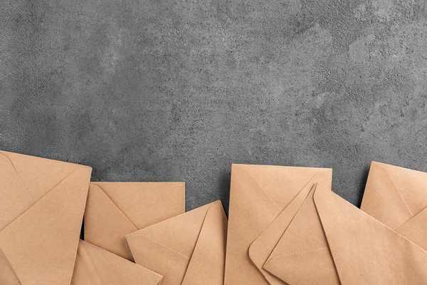 Envelopes castanhos sobre fundo cinzento, vista superior. Serviço de correio — Fotografia de Stock