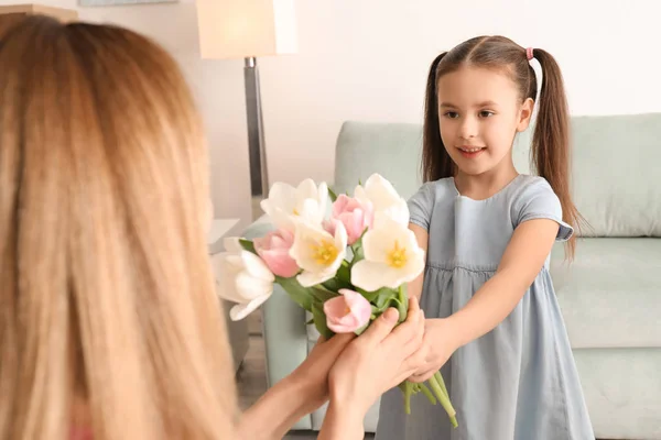 Mother receiving flowers from her cute little daughter at home — Stock Photo, Image