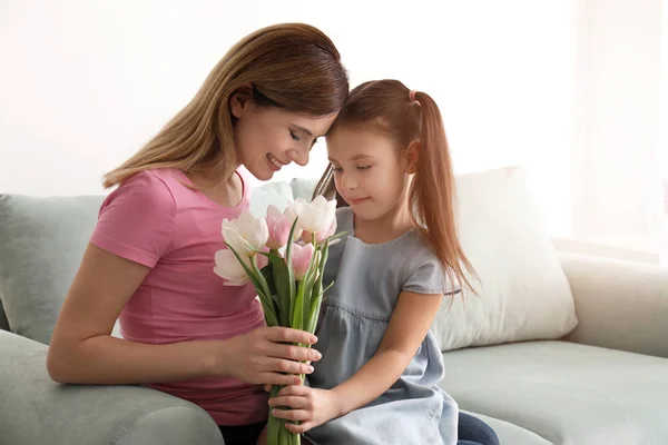 Мама получает цветы от своей милой маленькой дочери дома — стоковое фото