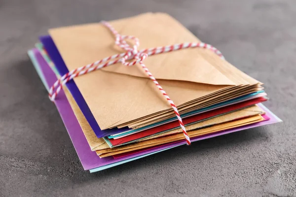 Stack of colorful envelopes on grey background. Mail service — Stock Photo, Image