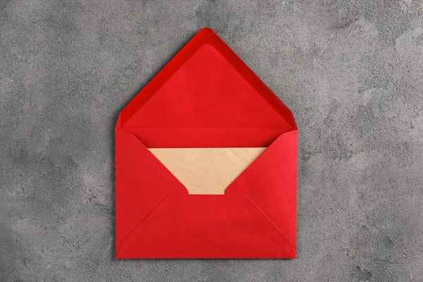 Envelope vermelho com cartão no fundo cinza, vista superior. Serviço de correio — Fotografia de Stock