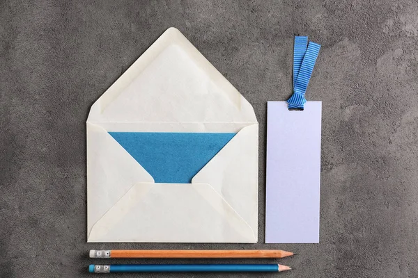 Lapos laikus összetétele a borítékot és a ceruza, a szürke háttér. Mail szolgáltatás — Stock Fotó
