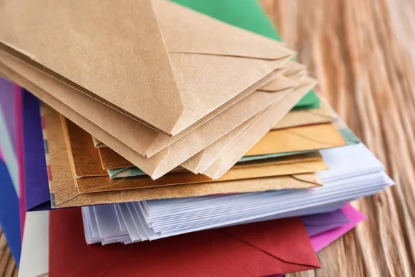 Pilha de envelopes coloridos em mesa de madeira, close-up. Serviço de correio — Fotografia de Stock