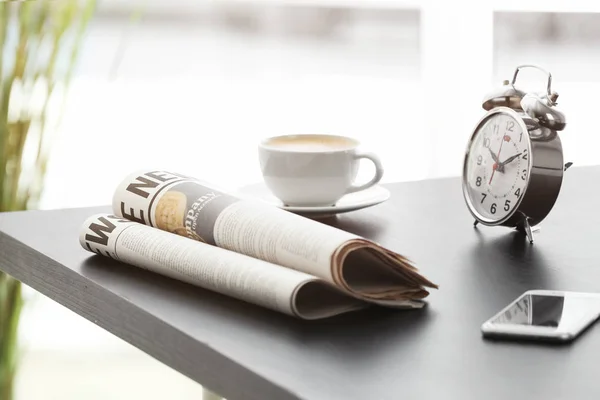 Ранкові газети, чашка гарячої кави та будильник на сірому столі — стокове фото