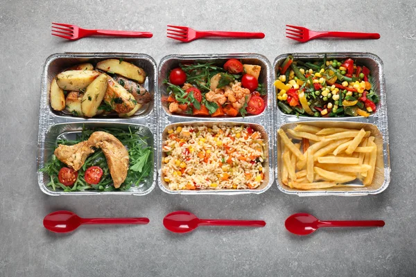 Food delivery containers with different meals on light table, top view — Stock Photo, Image