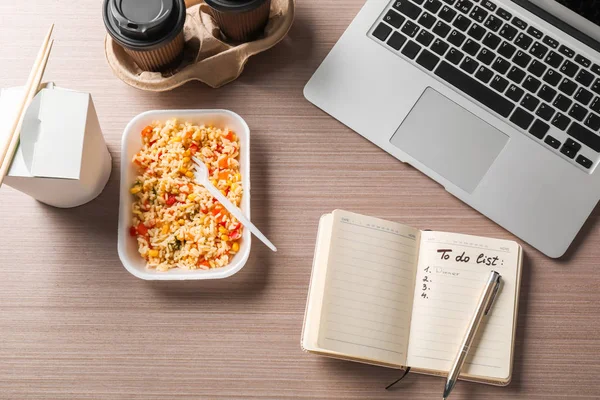 Containers with delicious meals, notebook and laptop on table. Concept of food delivery online — Stock Photo, Image