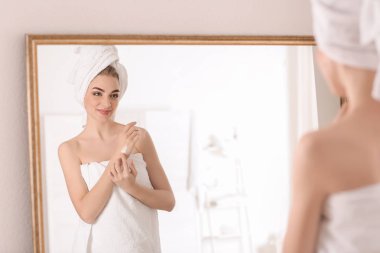 Genç kadın banyo cilt üzerine krem uygulamak