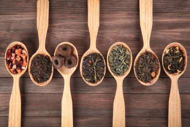 Düz ahşap zemin üzerine kaşık çay farklı türde, lay