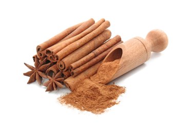 Tarçın tozlu kepçe ve beyaz arkaplanda çubuklar