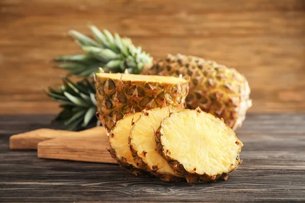 Sliced fresh pineapple on wooden table — Stock Photo, Image