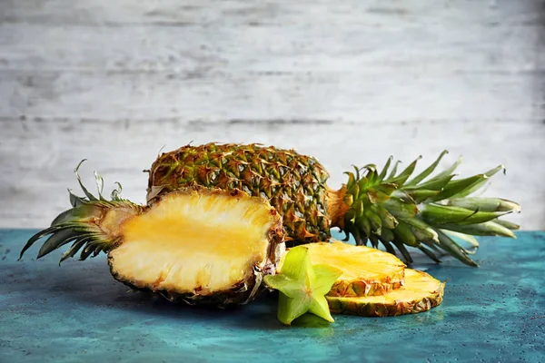 Piñas frescas maduras y fruta de la estrella en la mesa —  Fotos de Stock