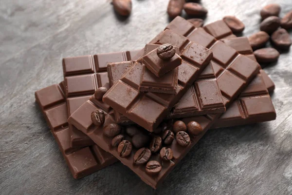 Milchschokolade mit Kaffeebohnen auf Holzgrund — Stockfoto