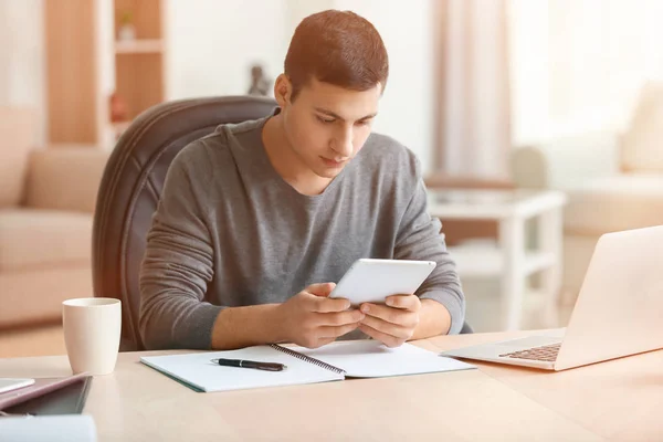 Junger Mann arbeitet im Homeoffice mit Tablet-PC — Stockfoto