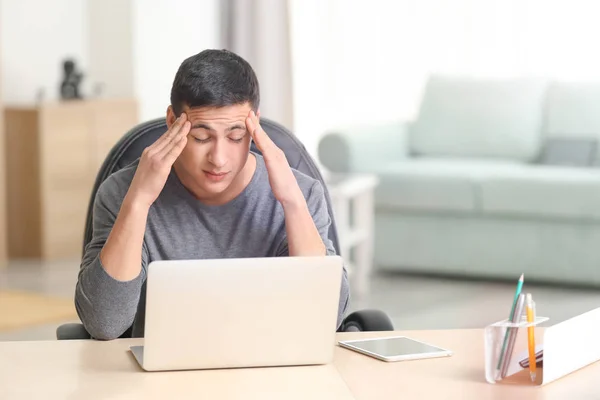 Emocjonalne młody mężczyzna pracujący z laptopa w domowym biurze — Zdjęcie stockowe