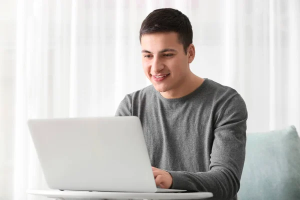 Young man working with laptop at home — Stock Photo, Image
