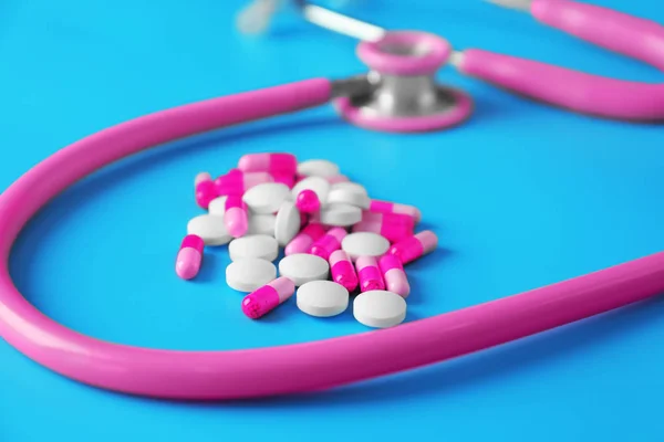 Stethoscope with pills on color background, closeup. Health care concept — Stock Photo, Image