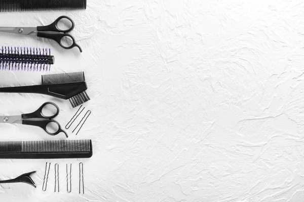 Профессиональные инструменты парикмахера на белом текстурированном фоне — стоковое фото
