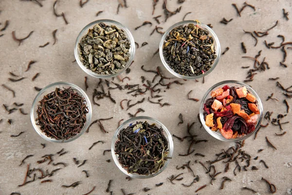 Verscheidenheid van droge thee in kommen op lichte achtergrond — Stockfoto