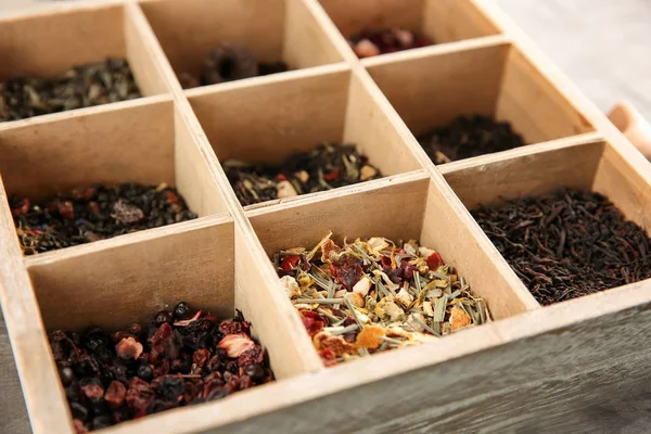 Variety of dry tea in wooden box, closeup