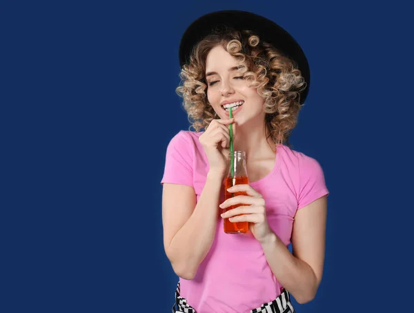 色背景にドリンクのボトルを持つ美しい若い女性の肖像画 — ストック写真