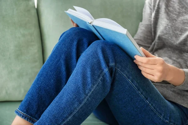 Joven mujer leyendo libro en sofá en casa —  Fotos de Stock