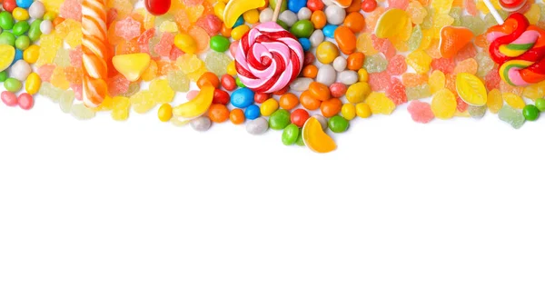 Chutné lízátka a barevné bonbóny na bílém pozadí — Stock fotografie