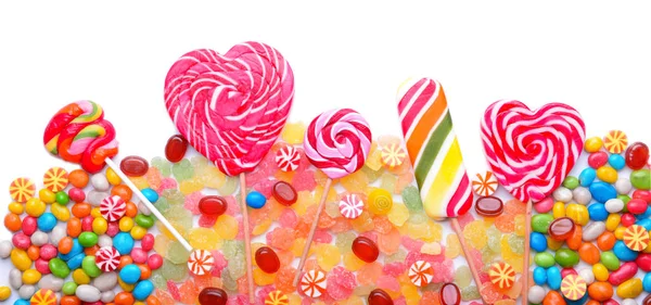 Смачні льодяники та барвисті цукерки на білому тлі — стокове фото