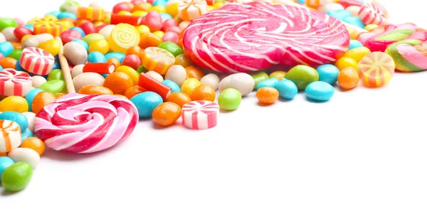 Смачні льодяники та барвисті цукерки на білому тлі — стокове фото