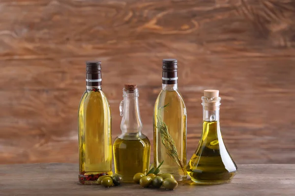 Sklo s olivovým olejem na dřevěné pozadí — Stock fotografie