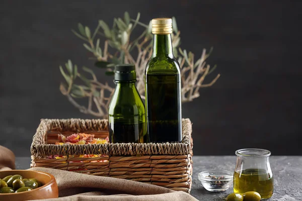 Wicker basket with bottles of olive oil on table — Stock Photo, Image