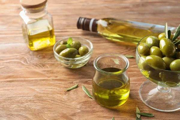 Jar with olive oil on wooden background — Stock Photo, Image