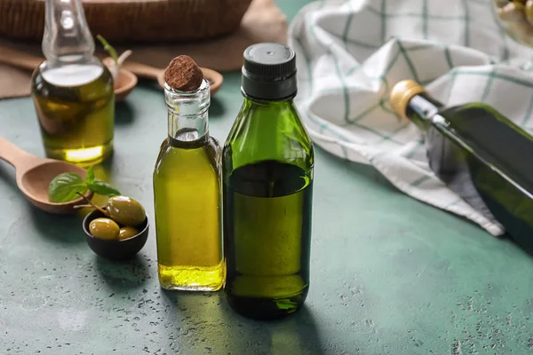 Botellas con aceite y aceitunas en la mesa — Foto de Stock