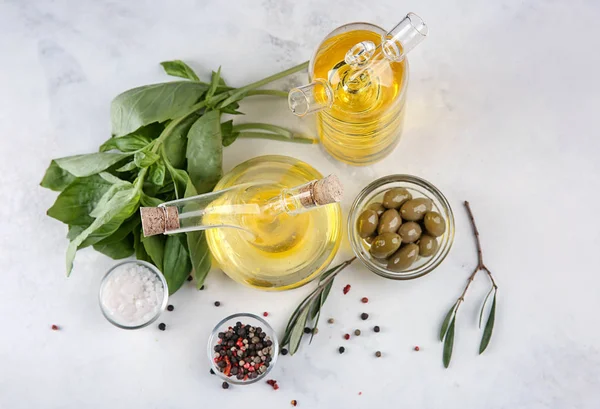 Botellas con aceite y aceitunas en la mesa — Foto de Stock