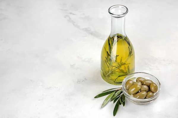 Botella con aceite y aceitunas sobre mesa — Foto de Stock