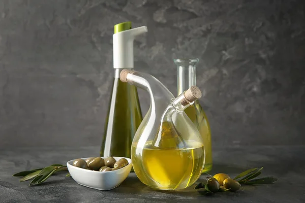 Glaswerk met olie en olijven op tafel — Stockfoto