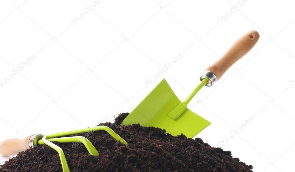 Gardening tools with soil on white background