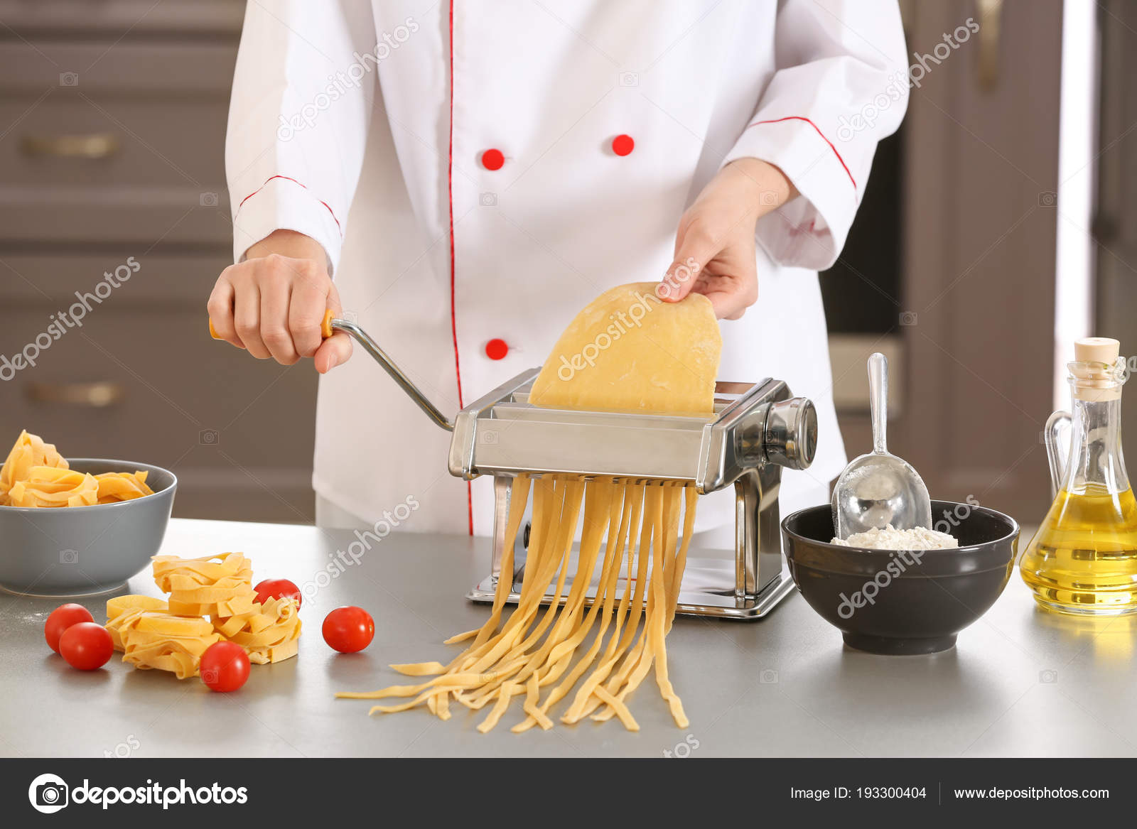Female chef making noodles with pasta machine at table Stock Photo by ©serezniy 193300404