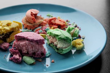 Koyu arka plan üzerinde ezilmiş macarons plakalı