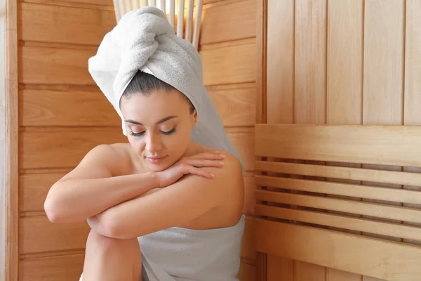 Young woman relaxing in sauna