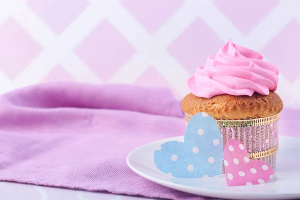 Delicioso cupcake con corazones de papel en la mesa. Celebración del Día de la Madre — Foto de Stock