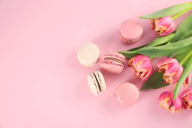 Lezzetli macarons ve çiçek renk arka plan üzerinde